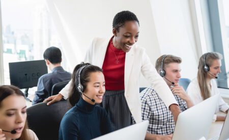 A group of call center agents working while a manager oversees