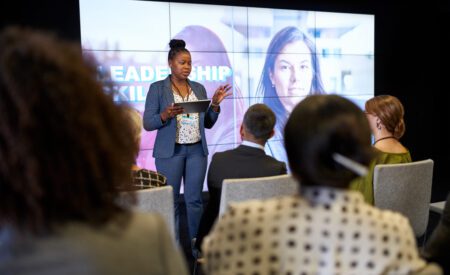 A professional gives a presentation to a large group at a conference.